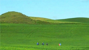 pelgrims in groen heuvelachtig landschap