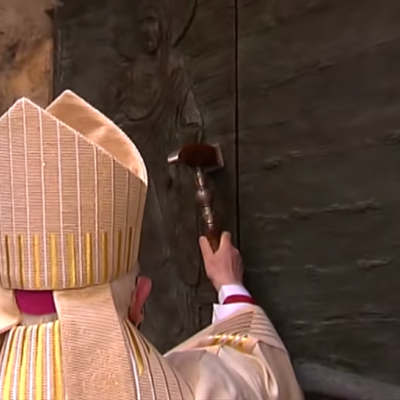 De aartsbisschop slaat met de ceremoniële hamer op de Heilige Deur