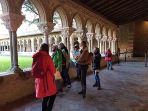 excursiedeelnemers in een kloostergalerij