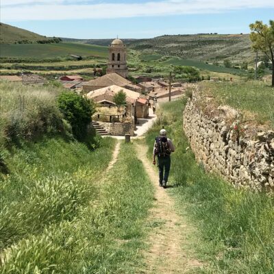 Pelgrim op een zandweg naar Hornillos del camino in zomers landschap