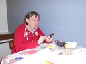 Pelgrim Ingeborg alleen aan tafel met mobiele telefoon 