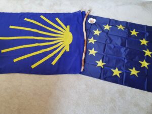 Santiagovlag en Europese vlag met daartussen Jacobsstaf en -schelp