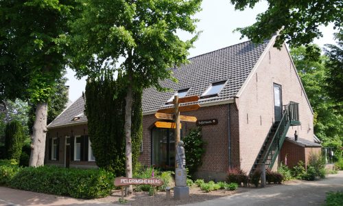 Pelgrimsherberg Kafarnaüm met daarvoor een paal met richtingaanwijzers